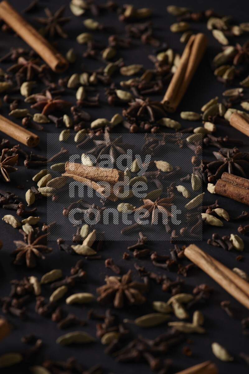 Cinnamon Sticks, Star anise, Cardamom and cloves on a black background