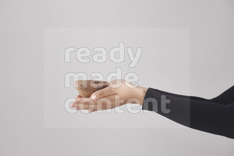 امرأة ترتدي عباءة سوداء تحمل أدوات خشبية مختلفة في أوضاع متعددة