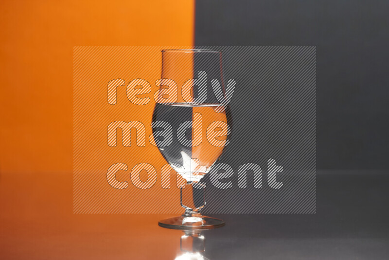 The image features a clear glassware filled with water, set against orange and black background