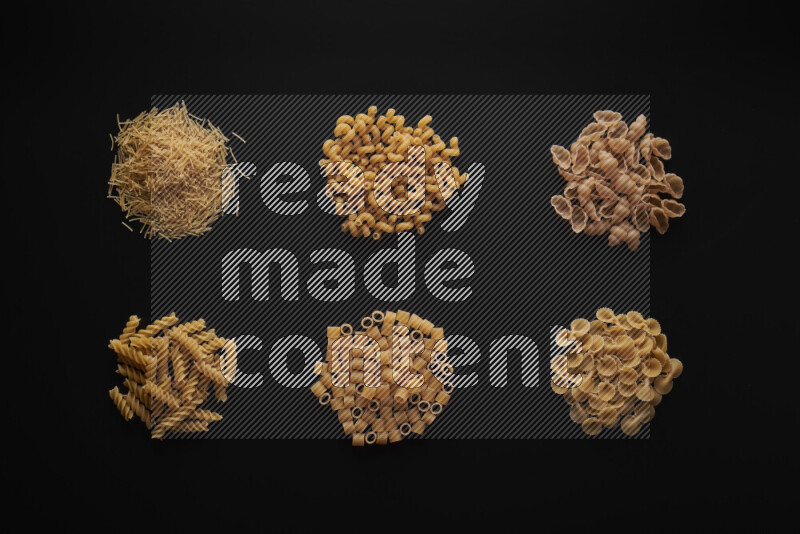 Different pasta types in bunches on black background