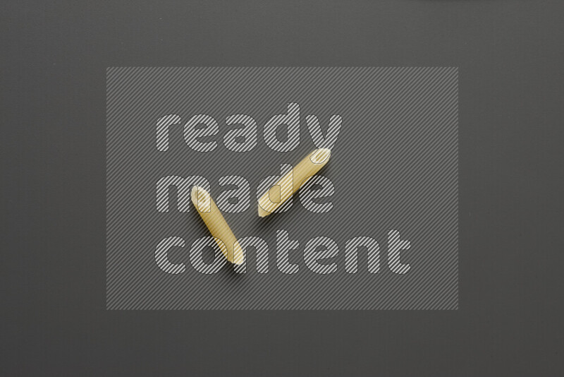 Mini penne pasta on grey background