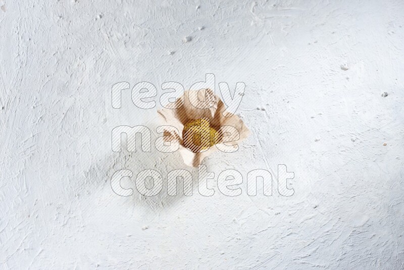 Turmeric powder in a crumpled piece of paper on textured white flooring