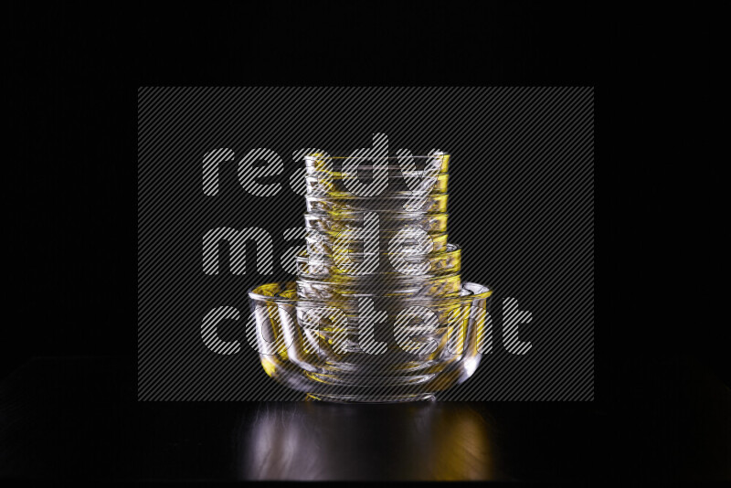 Glassware with rim light in yellow and white against black background