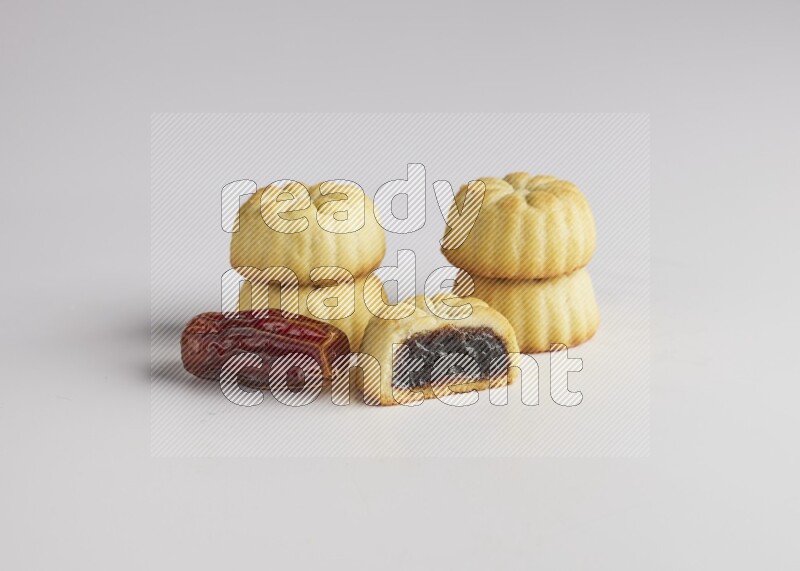 Five Pieces of Maamoul filled with date one of them is cut direct on white background
