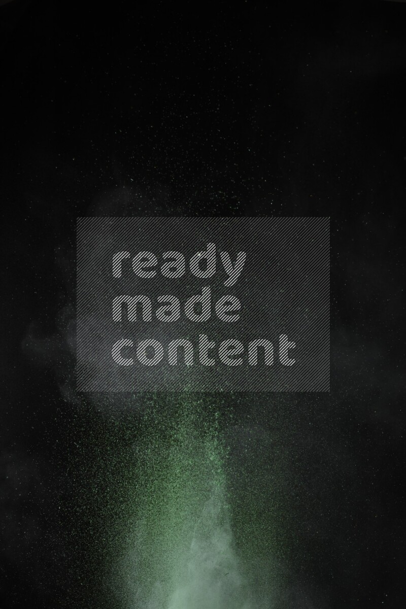 A side view of green powder explosion on black background