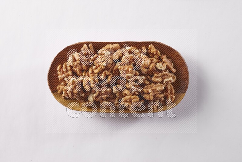 Walnuts in a wooden plate on white background
