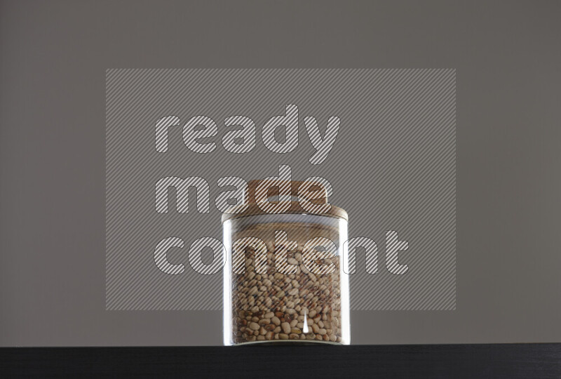 Black-eyed peas in a glass jar on black background