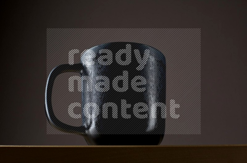 Low angle shot of a black cup on grey background