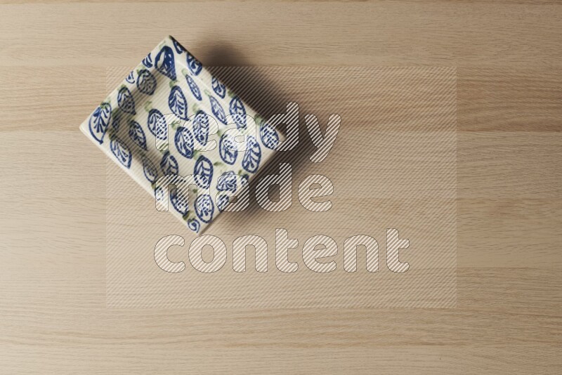 A decorative pottery plate on light wooden background