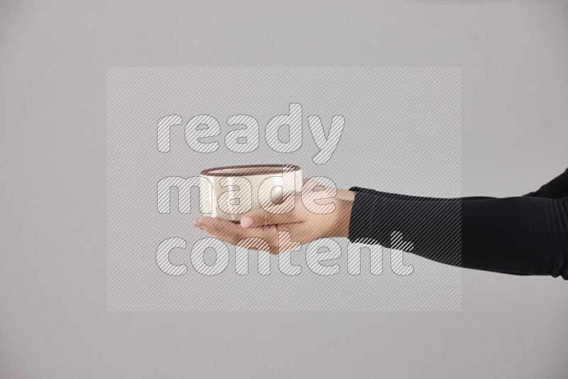 A woman in black abaya holding different pottery essentials in different positions