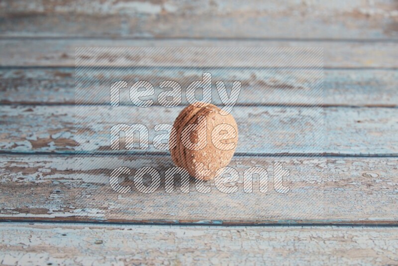 45º Shot of Brown Hazelnuts macaron on light blue wooden background