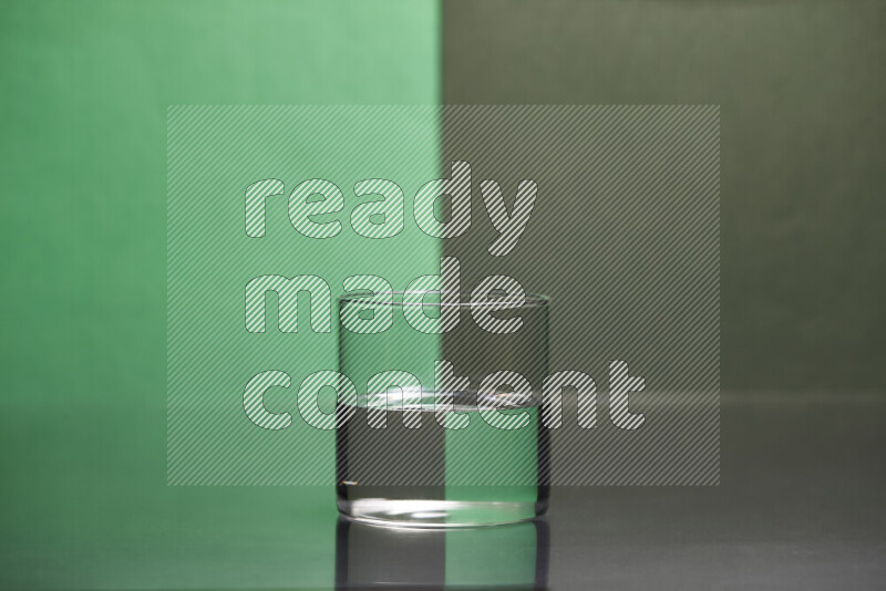 The image features a clear glassware filled with water, set against green and dark green background