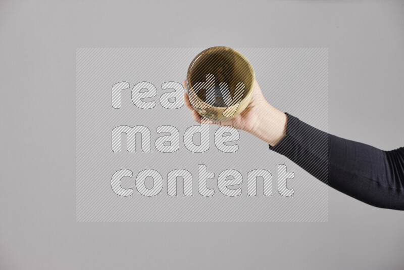 A woman in black abaya holding different pottery essentials in different positions