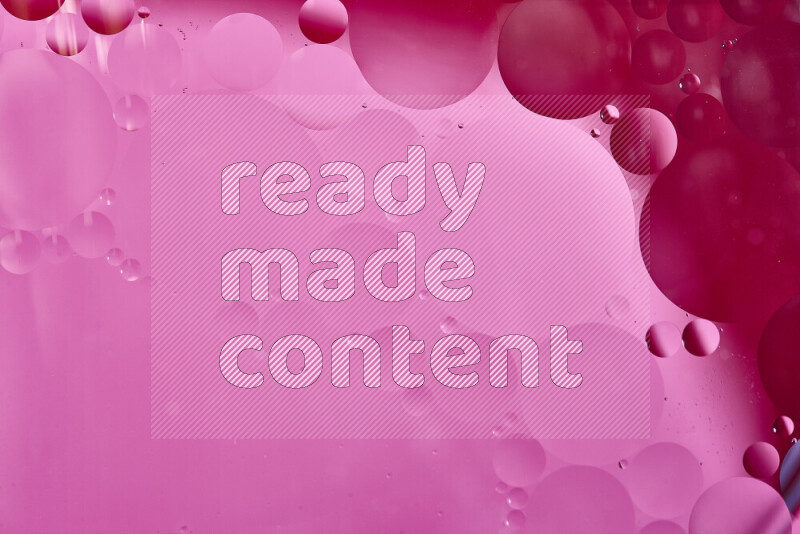 لقطات مقربة لفقاعات من الزيت على سطح الماء باللون الأحمر والوردي