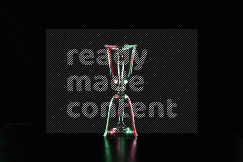 Glassware with rim light in red and green against black background