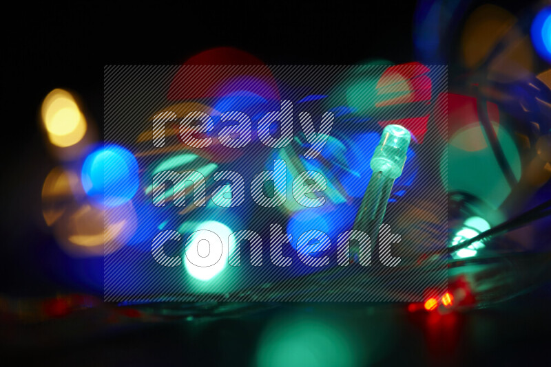 Light bulbs glowing against backdrop of multicolord bokeh
