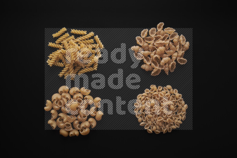 Different pasta types in bunches on black background