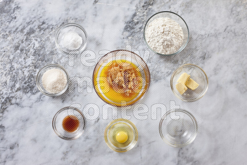 Cookies step by step with its ingredient, flour, butter, brown sugar, egg, vanilla extract, white sugar, chocolate chips and baking soda on grey marble background
