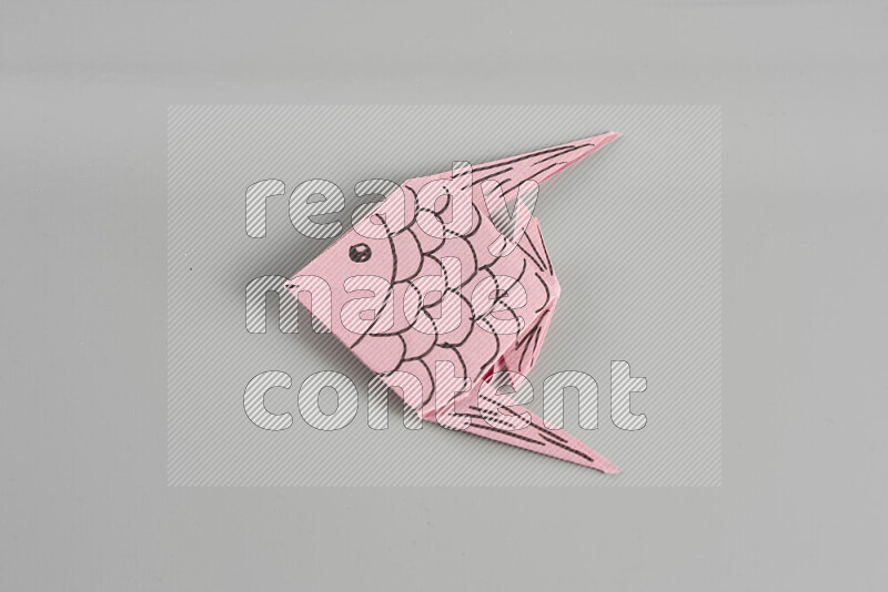 Origami fish on grey background