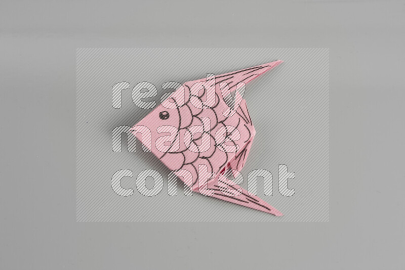Origami fish on grey background