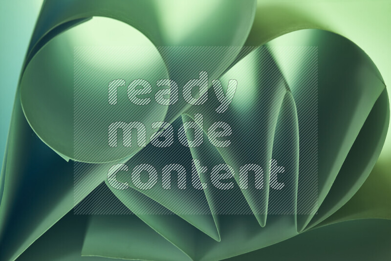 An artistic display of paper folds creating a harmonious blend of geometric shapes, highlighted by soft lighting in green tones