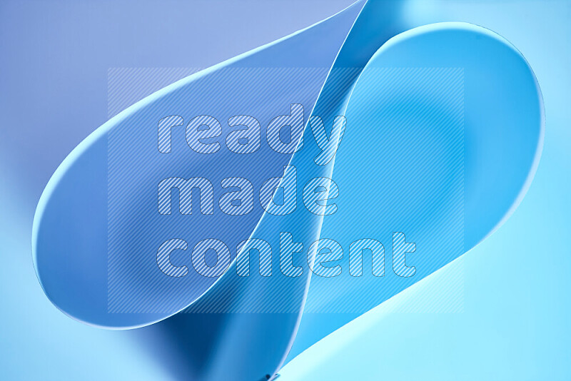 An abstract art of paper folded into smooth curves in blue gradients