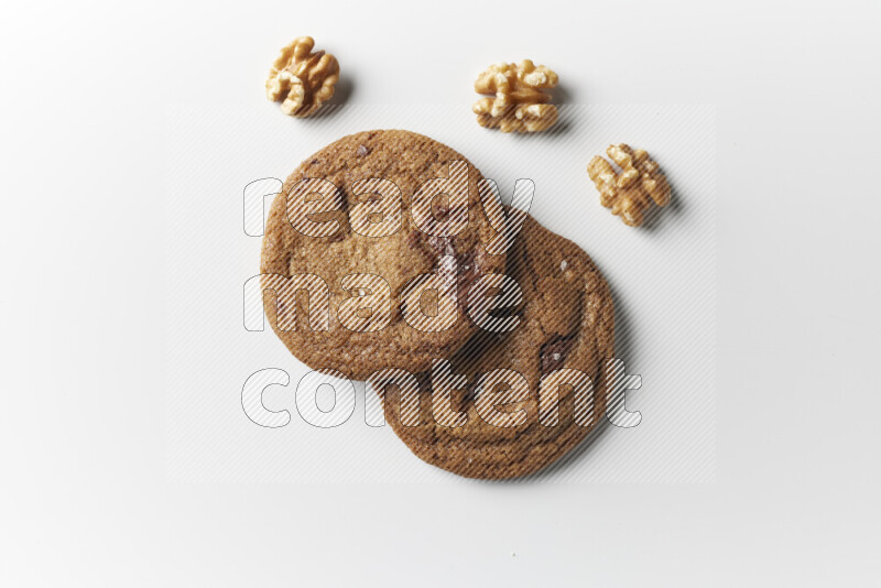 Chocolate chips cookies with walnuts beside it on a white background