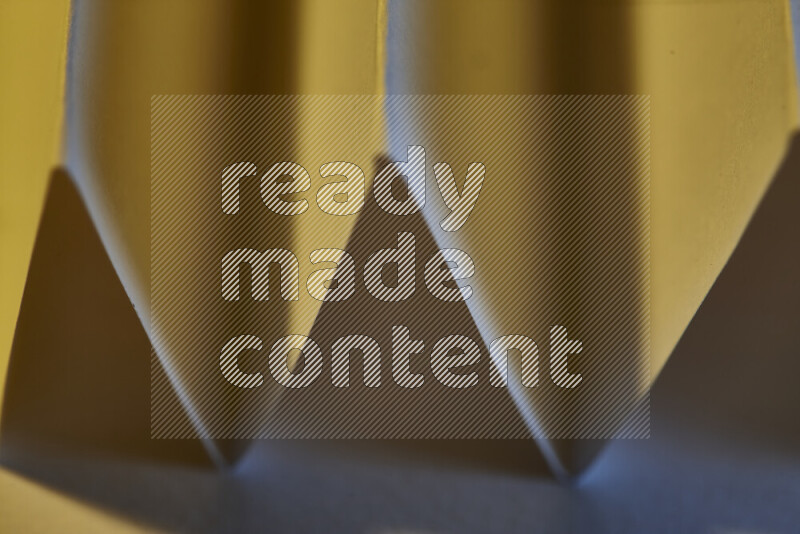 صورة مجردة مقربة تظهر طيات ورقية هندسية حادة بتدرجات اللون الأزرق مع درجات لونية دافئة