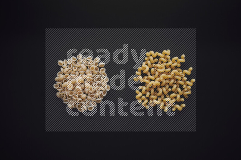 Different pasta types in bunches on black background