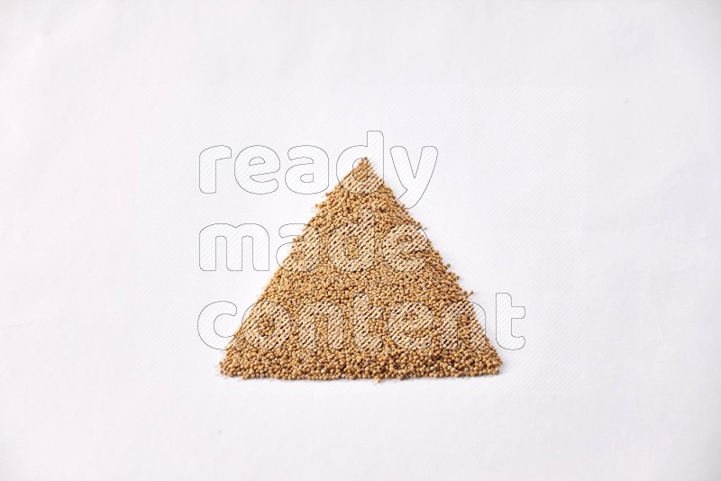 Mustard seeds in a triangle shape on a white flooring in different angles