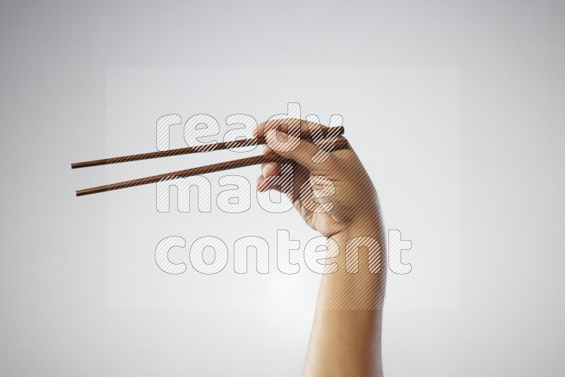 Male Hand Holding Chop Stick on white background