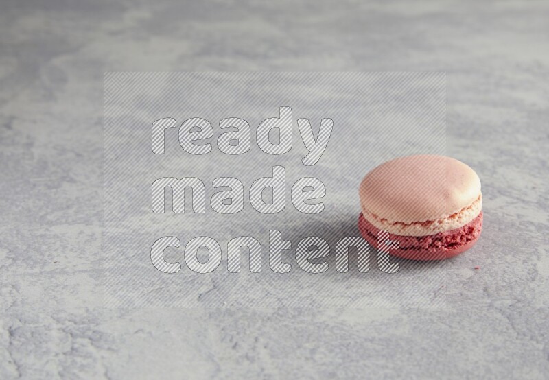 45º Shot of Pink Litchi Raspberry macaron on white  marble background