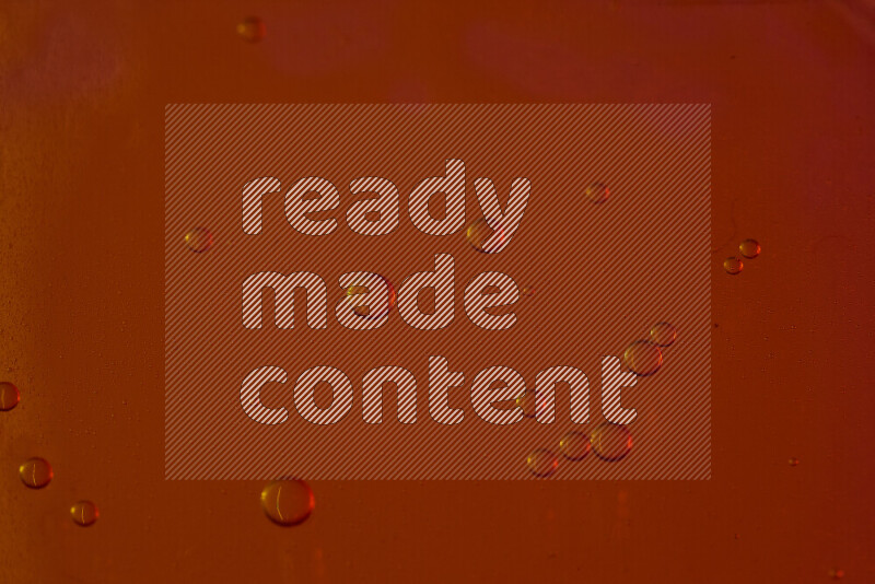 لقطات مقربة لقطرات من الماء على سطح الزيت على خلفية حمراء