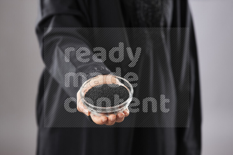 امرأة ترتدي عباءة تحمل أنواع مختلفة من البهارات في أوضاع متعددة