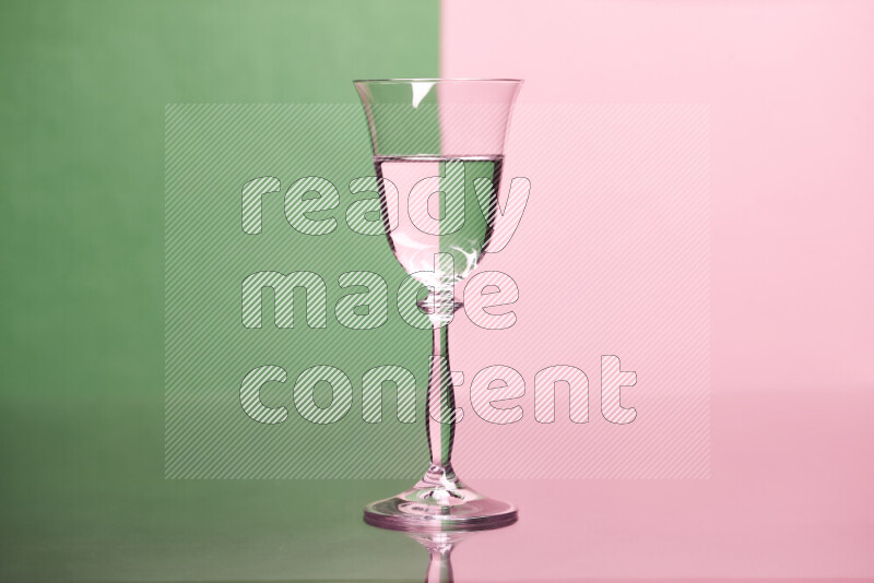 The image features a clear glassware filled with water, set against green and rose background