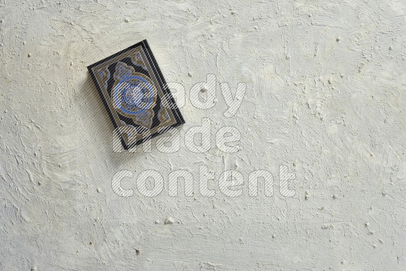 Quran with a prayer beads on textured white background