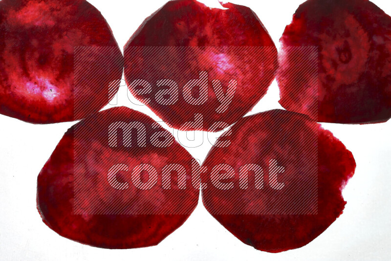 Beet slices on illuminated white background