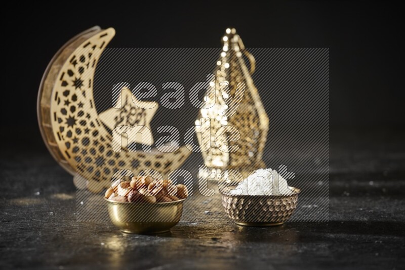 مكسرات في وعاء معدني مع جوز الهند المجفف بجانب فوانيس ذهبية علي خلفية سوداء