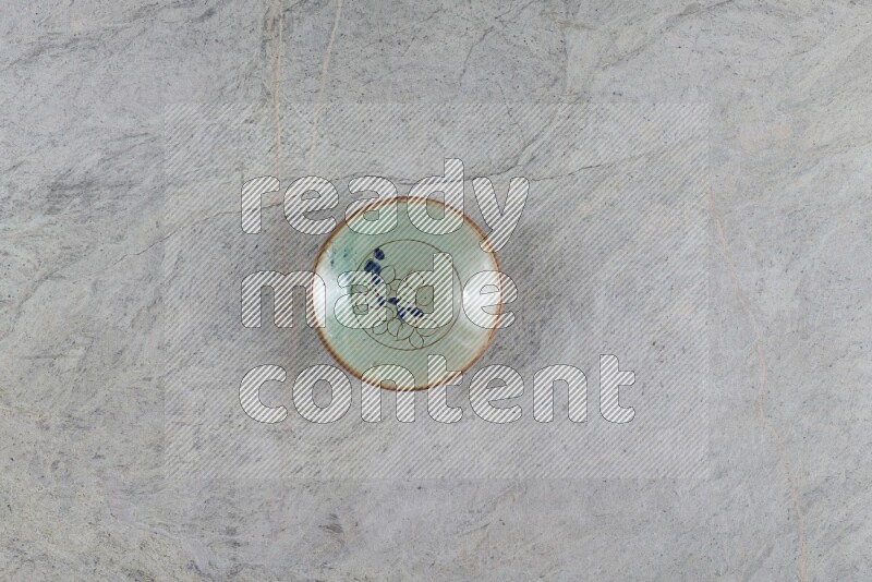 A decorative pottery plate on grey marble background