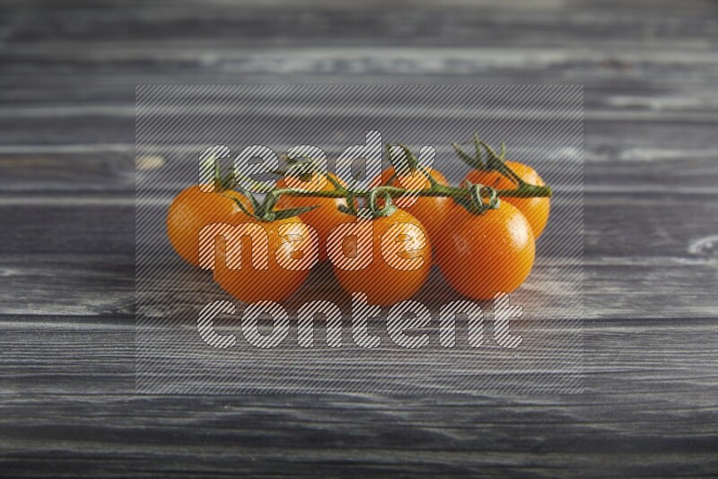 orange cherry tomato vein on a textured grey wooden background 45 degree