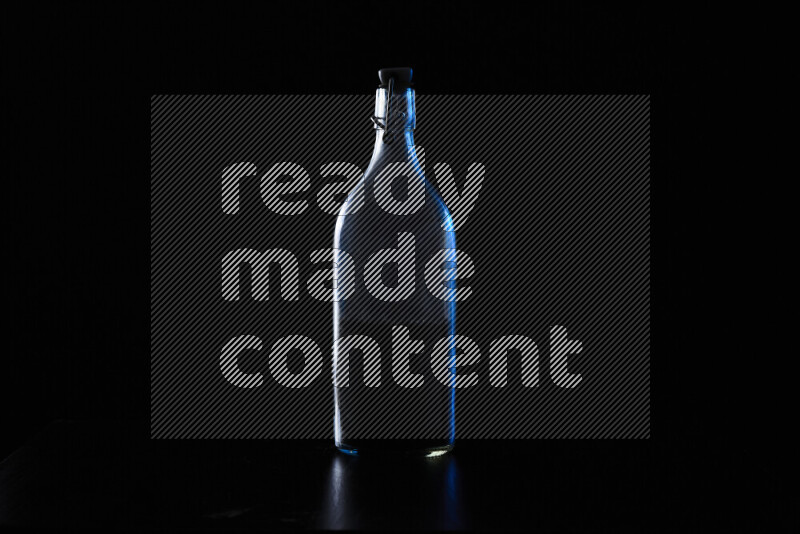 Water bottle with colored rim light against black background