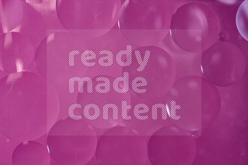 لقطات مقربة لفقاعات من الزيت على سطح الماء باللون الوردي