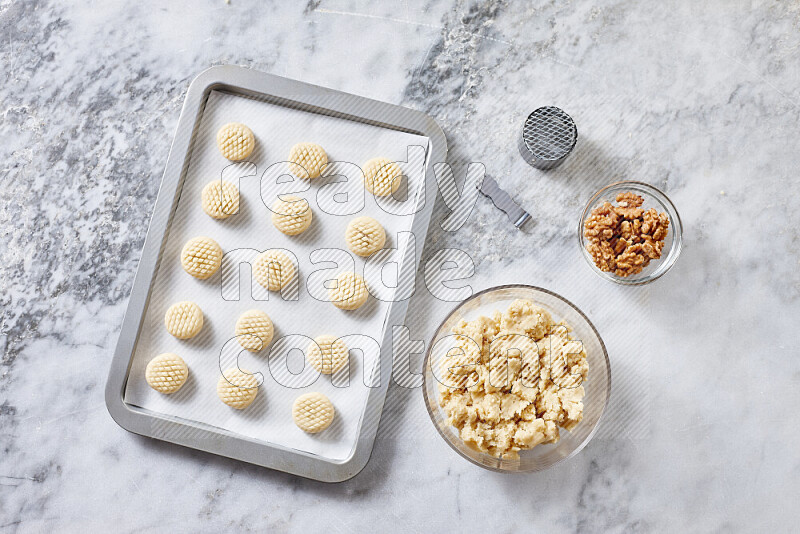 Kahk step by step with its ingredients ghee, sugar, flour, sesame, yeast, water and kahk flavor on grey marble background