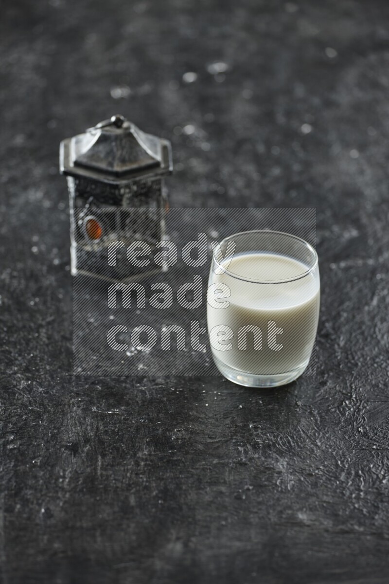 فانوس فضي مع مشروبات مختلفة وتمر ومكسرات وسبحة صلاة وقرآن على خلفية سوداء