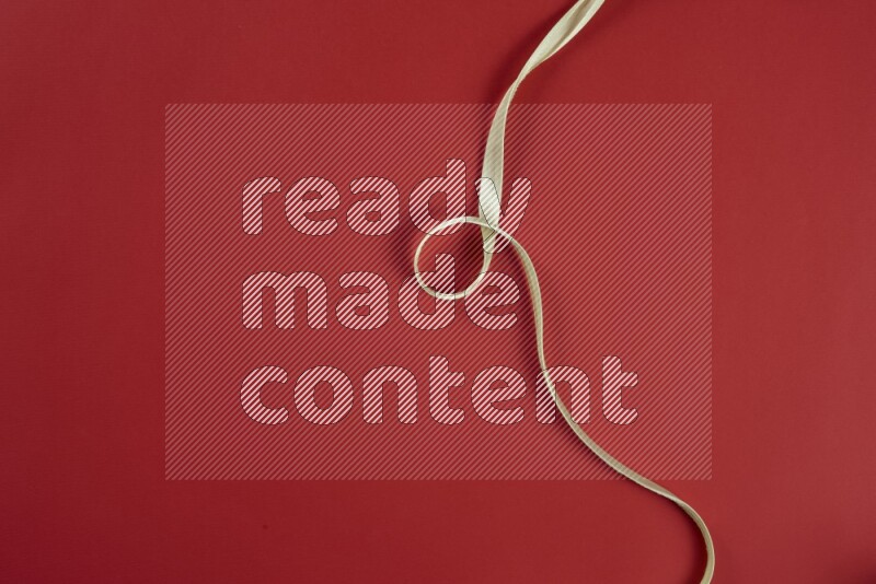 A green and red collection of sewing and tailoring tools arranged on a red background
