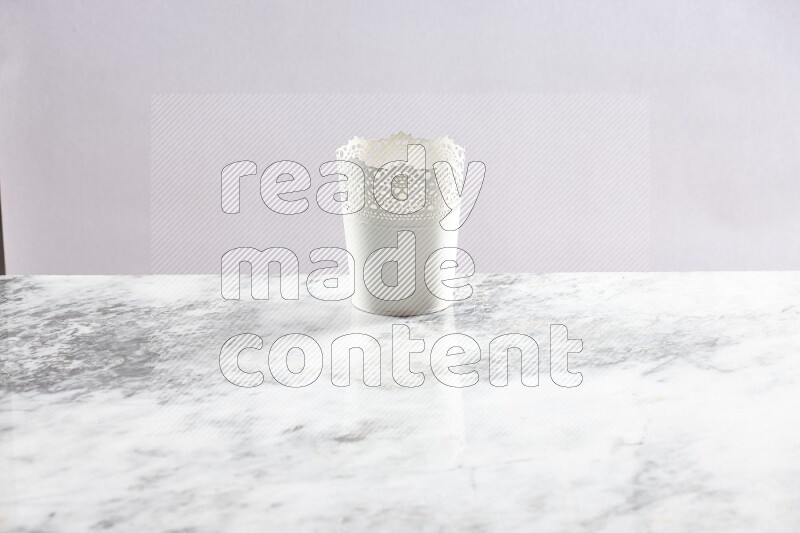 An empty white plant pot on grey marble background