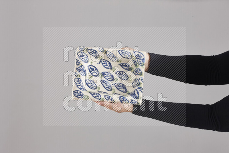 امرأة ترتدي عباءة سوداء تحمل أدوات فخارية مختلفة في أوضاع متعددة