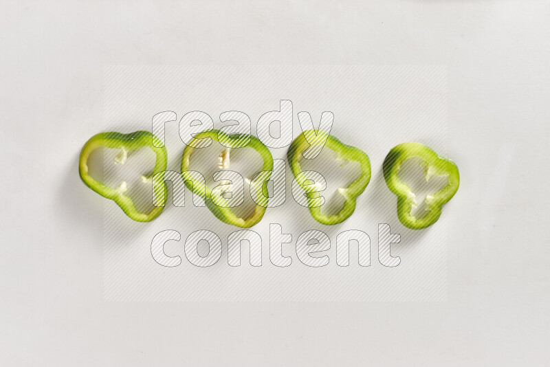 Green bell pepper slices on white background