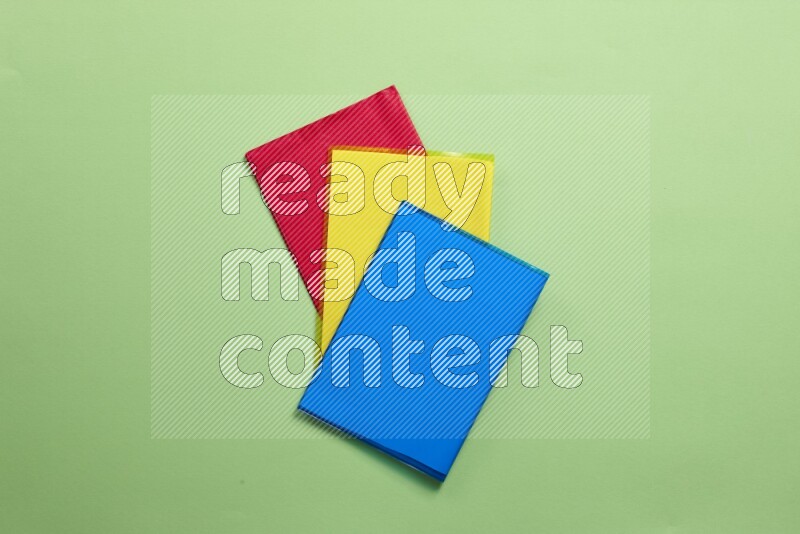 Multicolored notebooks on green background