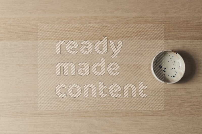 A multicolored pottery bowl on light wooden background